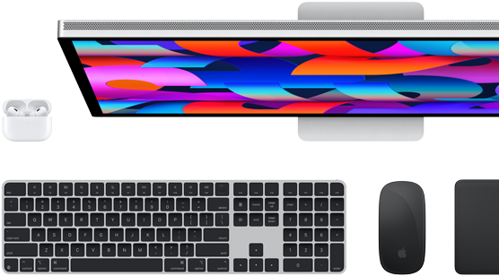 Bovenaanzicht van Studio Display-monitor, zwart Magic Keyboard, zwarte Magic Mouse, zwarte Magic Trackpad en witte AirPods-case